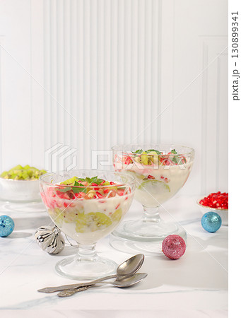 Christmas and New Year's dishes. Kiwi and pomegranate parfait on a bright festive table, an idea for decorating food and decorating New Year's dishes. Banner for the screen ,template for creativity Christmas and New Year's dishes. Kiwi and pomegranate parfait on a bright festive table, an idea for decorating food and decorating New Year's dishes. Banner for the screen ,template for creativity 130899341