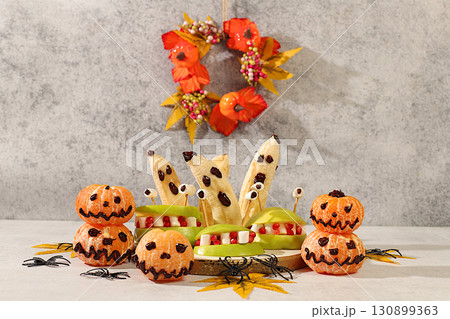 Halloween food concept. Scary monsters made of apples, tangerines and banana ghosts on an old concrete background, cafe and menu advertising, restaurant business card, Halloween food concept. Scary monsters made of apples, tangerines and banana ghosts on an old concrete background, cafe and menu advertising, restaurant business card, 130899363