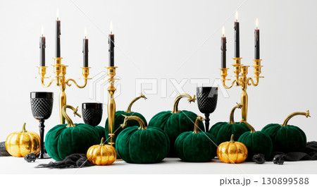 Elegant Halloween composition with velvet green and gold pumpkins, black glasses, and candelabras 130899588