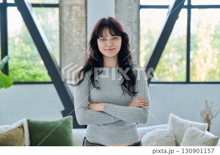 Portrait of confident successful young woman posing with crossed arms at home 130901157