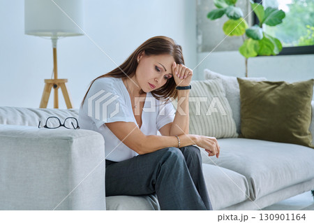 Mature sad woman experiencing stress, mental and physical pain, at home 130901164
