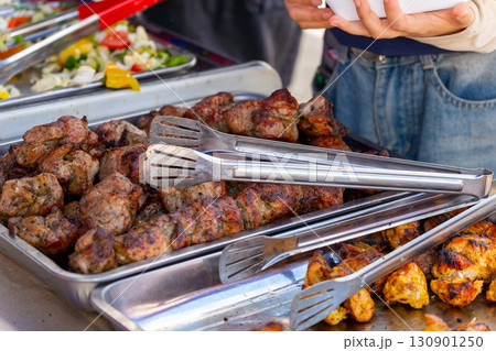 Sizzling street food feast: grilled sausages, shashlik, and golden french fries 130901250