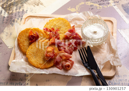 A portion of golden potato pancakes, fried with crispy bacon 130901257