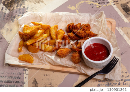 Crispy chicken nuggets and french fries 130901261