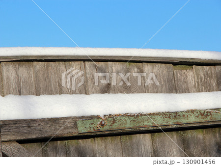 Layer of snow on the fence. Winter has come. Frosty weather. Countryside life Layer of snow on the fence. Winter has come. Frosty weather. Countryside life 130901456