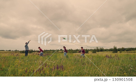 Joyful family moments outside, father with son and daughter flying kite, adventure under cloudy sky, connecting through play, dreaming to fly together, nature s magic for kids, laughter carried by 130901508