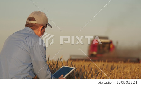 farmer working in wheat field, combine harvester ploughing in wheat field, agriculture tablet, innovations in agriculture, sustainable farming practices, maximizing harvest efficiency, connecting farmer working in wheat field, combine harvester ploughing in wheat field, agriculture tablet, innovations in agriculture, sustainable farming practices, maximizing harvest efficiency, connecting 130901521