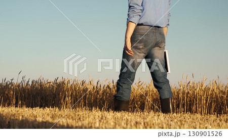 man wearing blue jeans blue shirt standing field. holding book hand, Business growth through smart farming, Data driven decisions agriculture, Precision farming with tablets, Efficiency wheat 130901526