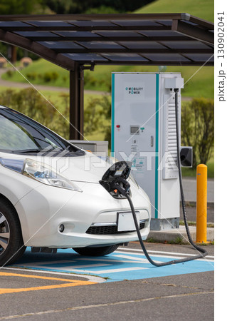 充電ステーションで充電中の電気自動車 充電ステーションで充電中の電気自動車 130902041
