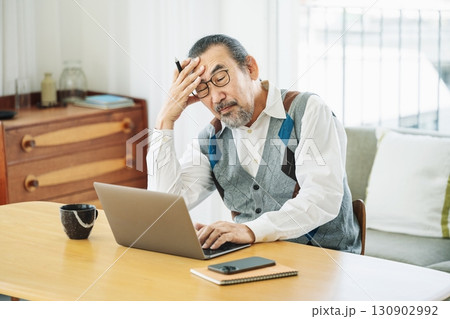 パソコンを見て悩むシニア男性 130902992