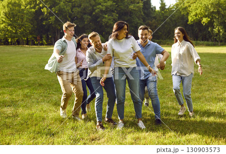 Group of happy young friends relaxing, having fun and hugging in a green summer park Group of happy young friends relaxing, having fun and hugging in a green summer park 130903573