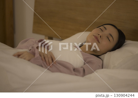 ベッドで眠る女性 130904244