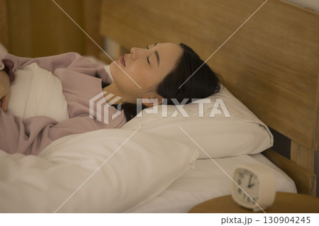 ベッドで眠る女性 130904245