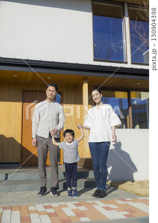 家の前に立つ家族  130904398