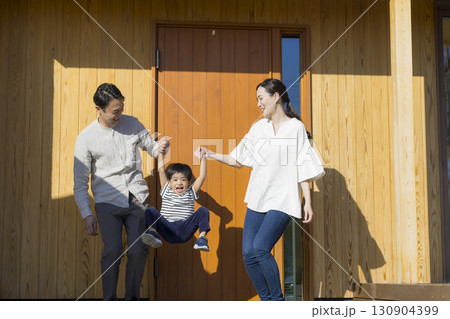 家の前に立つ家族  130904399