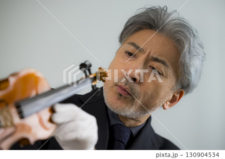 バイオリンをメンテナンスするシニア男性 バイオリンをメンテナンスするシニア男性 130904534