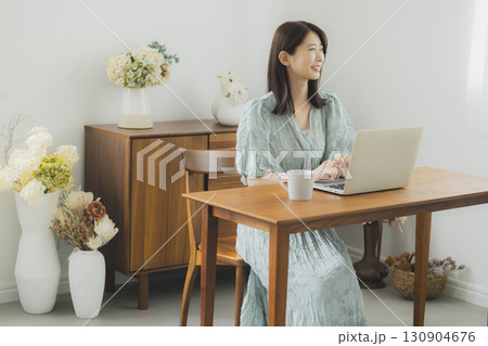 部屋でパソコンを見る女性  130904676