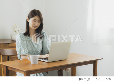部屋でパソコンを見る女性 部屋でパソコンを見る女性 130904680