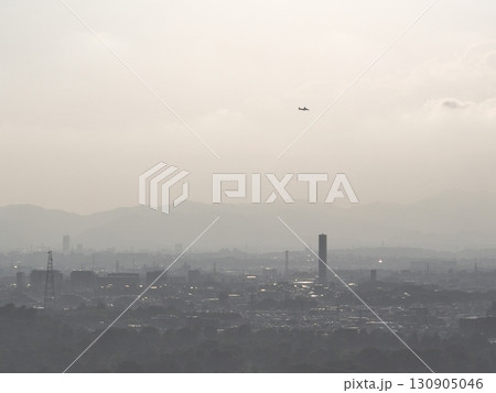 （鳥瞰）　夕暮れの街上空から調布飛行場に向けて着陸する小型旅客機 130905046