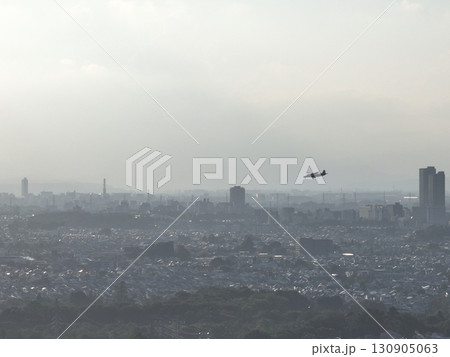 （鳥瞰）　夕暮れの街上空から調布飛行場に向けて着陸する小型旅客機 130905063