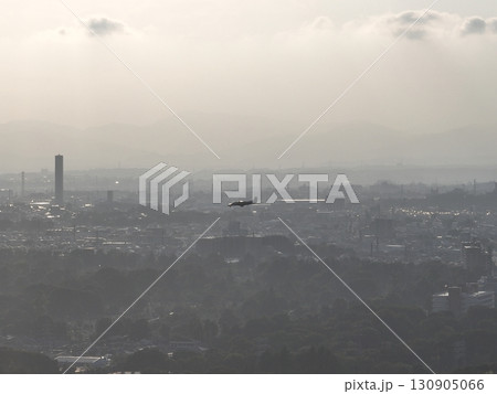 （鳥瞰）　夕暮れの街上空から調布飛行場に向けて着陸する小型旅客機 130905066
