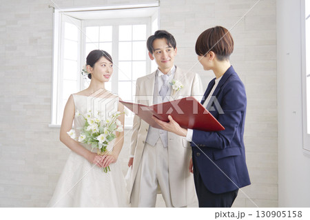新郎新婦と打ち合わせする結婚式の司会者 新郎新婦と打ち合わせする結婚式の司会者 130905158
