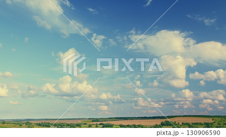 A Beautiful and Cloudy Sky Over an Expansive Green Landscape That Captivates the Eye A Beautiful and Cloudy Sky Over an Expansive Green Landscape That Captivates the Eye 130906590