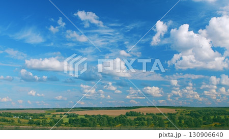 A Serene and Beautiful Landscape Featuring a Clear Blue Sky and Fluffy White Clouds Above A Serene and Beautiful Landscape Featuring a Clear Blue Sky and Fluffy White Clouds Above 130906640