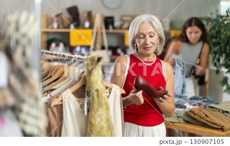 Elderly women choosing high heel shoes in store Elderly women choosing high heel shoes in store 130907105