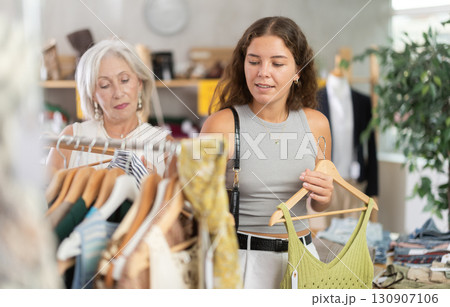 Elderly and young women choosing summer clothes in store 130907106
