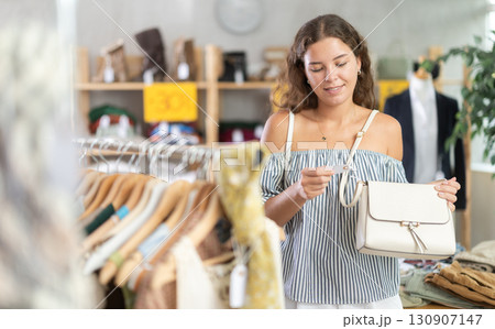 Young women choosing handbag in store Young women choosing handbag in store 130907147
