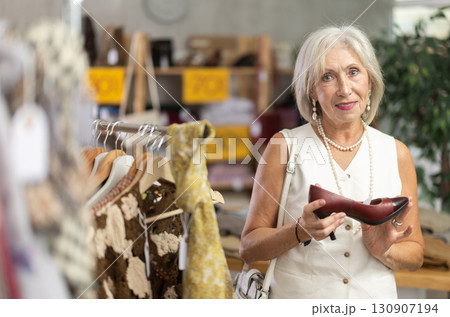 Mature woman choosing heels in clothing store 130907194