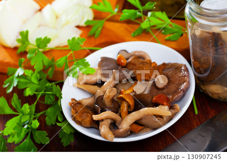 Various canned mushrooms, onions and greens on wooden table 130907245