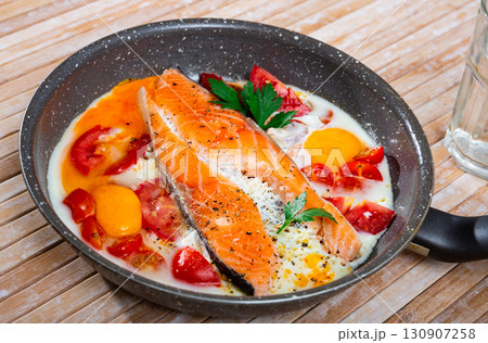 Fried eggs with salmon and cherry tomato 130907258