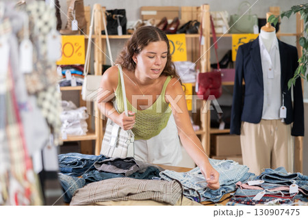 Young woman choosing jeans in clothing store Young woman choosing jeans in clothing store 130907475