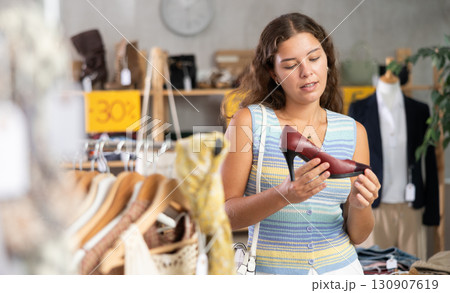 Young woman choosing high heel shoes in store Young woman choosing high heel shoes in store 130907619