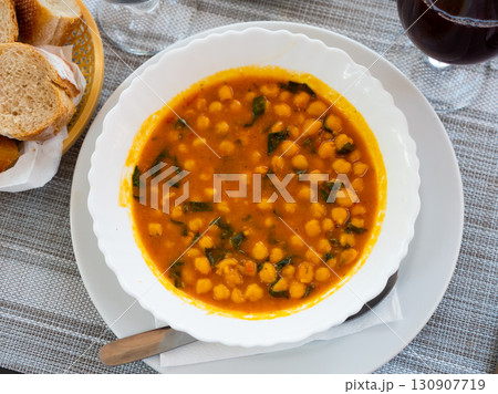 Stewed curried chickpeas with spinach on white plate 130907719
