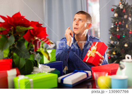 Man sitting at the table with X-mas presents 130907766