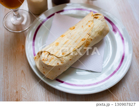 Turkish wrapped dish durum on white plate Turkish wrapped dish durum on white plate 130907827