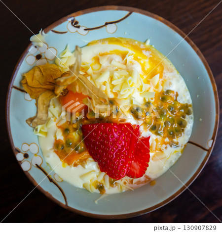 Delicate passion fruit mousse with yogurt, strawberry and physalis 130907829