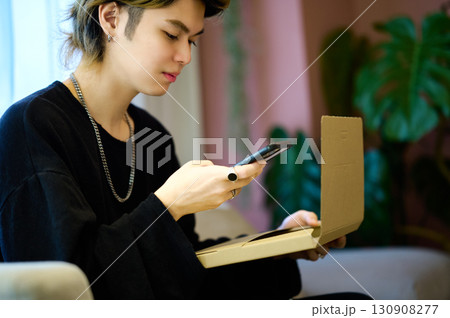 荷物の前でスマホを操作するZ世代の男性 荷物の前でスマホを操作するZ世代の男性 130908277