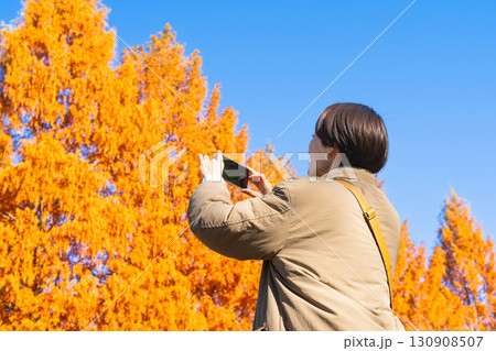 紅葉をスマートフォンで撮影している女性 ライフスタイルイメージ 紅葉をスマートフォンで撮影している女性 ライフスタイルイメージ 130908507
