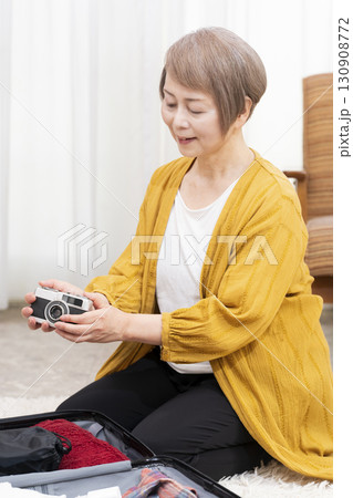 旅行の荷造りをするシニア女性 130908772