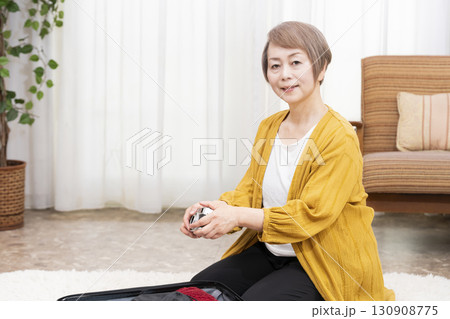 旅行の荷造りをするシニア女性 130908775
