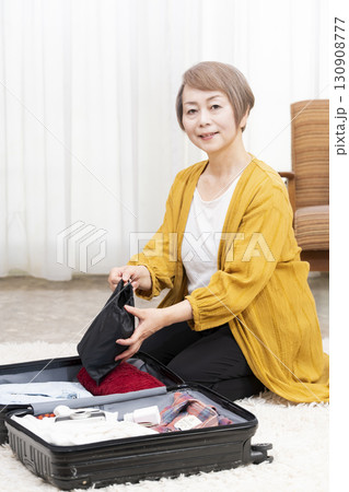 旅行の荷造りをするシニア女性 130908777