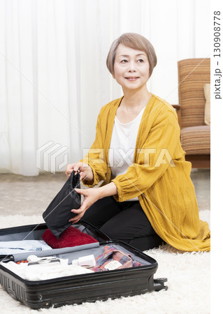 旅行の荷造りをするシニア女性 130908778
