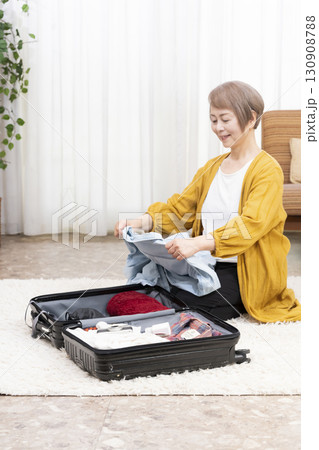 旅行の荷造りをするシニア女性 130908788