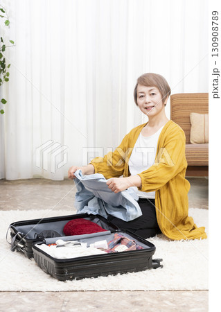 旅行の荷造りをするシニア女性 旅行の荷造りをするシニア女性 130908789