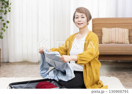 旅行の荷造りをするシニア女性 130908791
