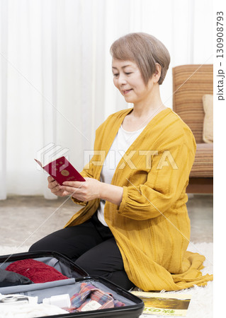 旅行の荷造りをするシニア女性 130908793